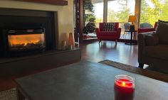 a living room filled with furniture and a fire place in front of a large window