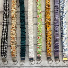 six different colored umbrellas are lined up on a white wooden surface with metal handles