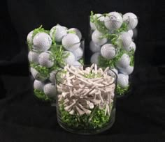 some golf balls and greens in a glass vase