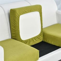 a green and white couch with two square pillows on it's backrests