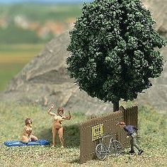 two miniature people standing next to a tree