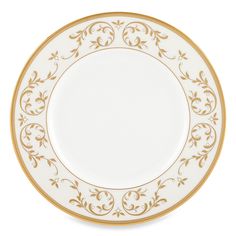 a white and gold plate with an ornate design on the rim, against a white background