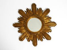 a gold sunburst mirror on a white wall