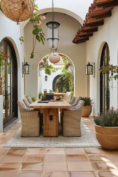 an outdoor dining area with potted plants and hanging lights