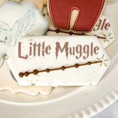 some cookies are sitting on a plate with the words little muggle written on them