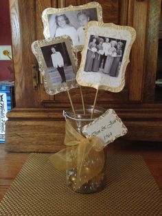 three pictures are placed in a glass jar on a place mat and tied with a brown ribbon