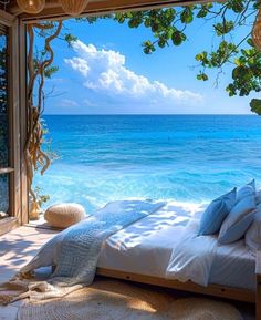 a bed sitting under a window next to the ocean