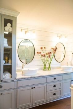 a bathroom with double sinks and two mirrors on the wall next to eachother