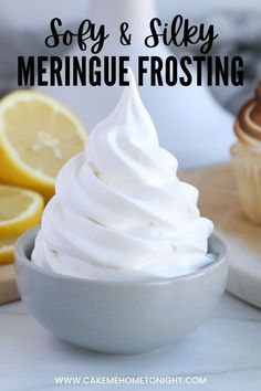 a bowl filled with meringue frosting next to lemons and muffins