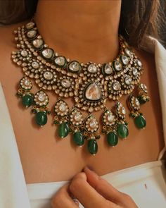 **Description This exquisite Sabyasachi-inspired green-colored grand uncut kundan necklace set embodies timeless elegance and opulence. Featuring a stunning array of uncut kundan stones, the necklace radiates a luxurious green hue that is both captivating and rich. The intricate craftsmanship showcases traditional Indian artistry, with each kundan meticulously set to create a dazzling effect. The set includes a matching pair of earrings that complement the necklace, making it a perfect choice for bridal wear or any special occasion where you want to make a statement. **Care Instructions 1. **Avoid Exposure to Chemicals Keep the necklace and earrings away from perfumes, hairsprays, and other chemicals that may tarnish or damage the stones and metal. 2. **Store Properly Store the jewelry in Luxury Kundan Temple Jewelry Necklace With Matching Earrings, Luxury Kundan Emerald Necklace For Ceremonial Occasions, Luxury Kundan Temple Jewelry Necklace For Festivals, Luxury Kundan Wedding And Engagement Jewellery, Green Necklace Indian Bridal, Sabyasachi Bridal Jewellery, Wedding Necklaces For Bride Indian, Luxury Gold Plated Kundan Necklace For Reception, Luxury Festive Kundan Necklace Gift