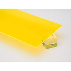 a yellow plastic object sitting on top of a white surface