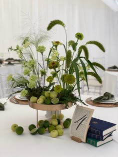 the table is set with books, flowers and other things to decorate it for an event