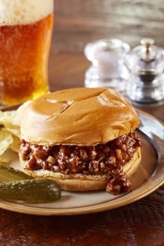 a sloppy joe sandwich on a plate with pickles