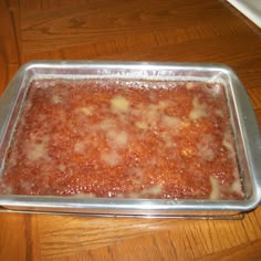 a metal pan filled with food on top of a wooden table