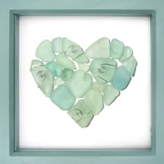 a heart made out of sea glass in a frame