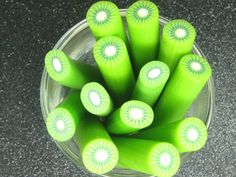 green candles are arranged in a glass bowl