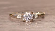 a diamond ring sitting on top of a wooden table