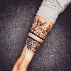 a woman's arm with a flower tattoo on the left side of her wrist