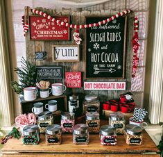 an assortment of hot chocolates on display in front of a sign and christmas decorations