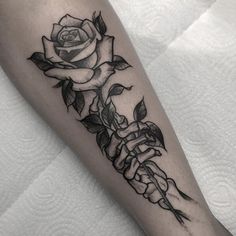 a black and white rose tattoo on the arm