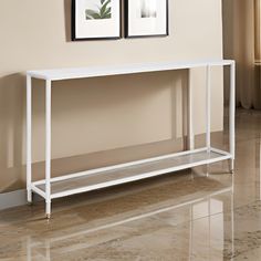 a white console table with two pictures on the wall