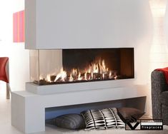 a modern fireplace in the middle of a living room with white walls and flooring