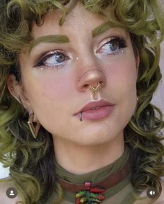 a woman with green hair and piercings on her nose