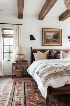 a bedroom with white walls and wood beams