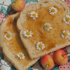 two pieces of bread with white flowers on them and some cherries around it, sitting on a floral plate