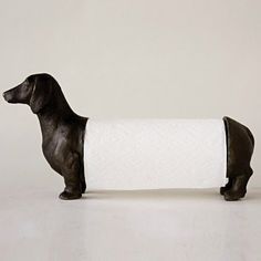 a dog figurine holding a roll of toilet paper