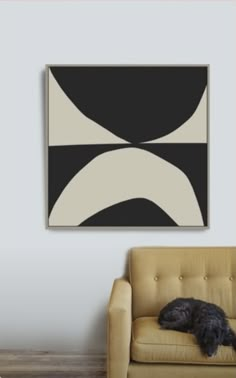 a black and white painting hanging on the wall above a couch with a dog sleeping on it