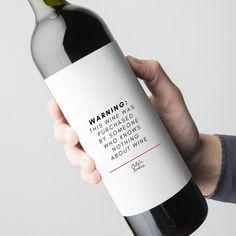 a person holding a bottle of wine in their left hand with the label on it