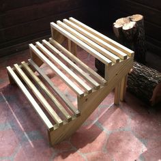 a wooden bench sitting on top of a tiled floor next to a tree stump in a room