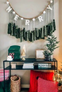 a christmas tree is hanging on the wall next to a table with books and decorations