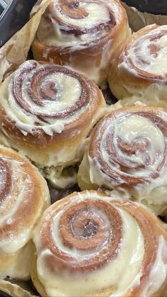 several cinnamon rolls in a pan with icing on them