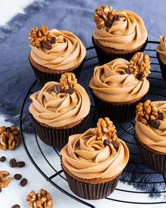 several cupcakes on a cooling rack with nuts