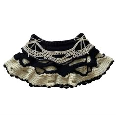 a black and white crocheted skirt with lace on the bottom is shown in front of a white background