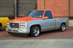 two trucks parked next to each other in front of a brick building