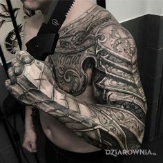 a man with tattoos on his arm holding a knife