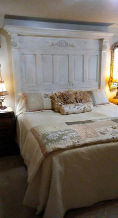 a bed with white headboard and pillows in a bedroom next to two lamps on either side of the bed