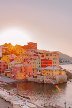 boats are parked on the shore in front of colorful buildings