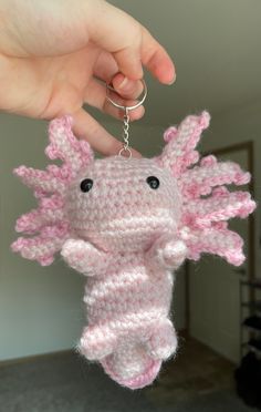 someone is holding up a crocheted key chain