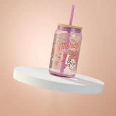 a pink tumbler cup with a straw in it sitting on top of a shelf