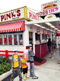 three children are standing in front of the pink's diner and krispy kreme