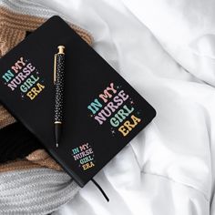 a black notebook with writing on it next to a pair of socks and a pen