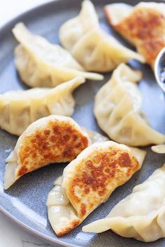 some dumplings are sitting on a plate with dipping sauce