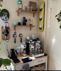 there is a coffee maker on the counter in this room with plants and other items