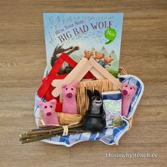 a basket filled with stuffed animals next to a book