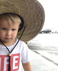 a young boy wearing a straw hat on top of his head