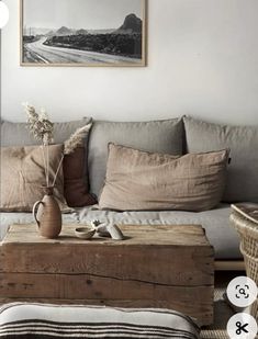 a living room with a couch, coffee table and wicker baskets on the floor